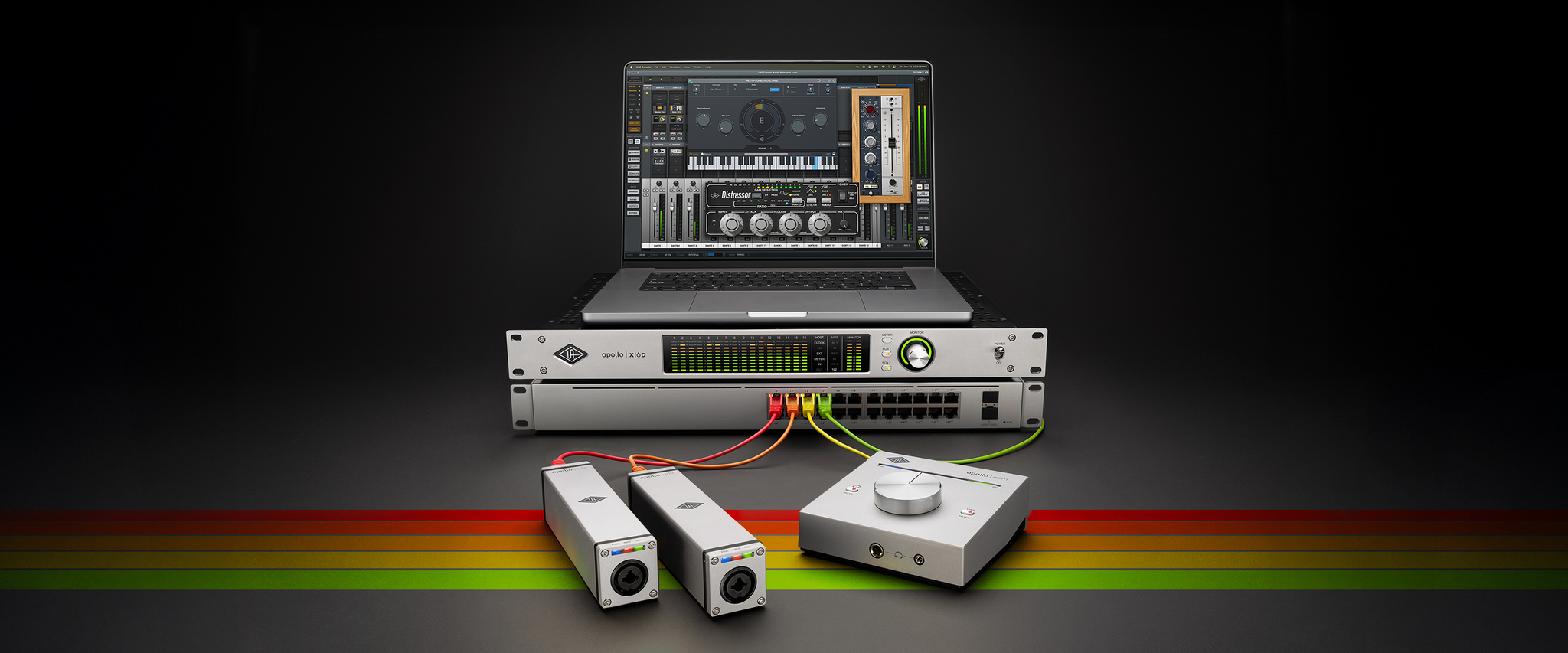 An Apollo x16D and a laptop rest on top of a DANTE switch, connected to the e1x and e2m external hardware devices