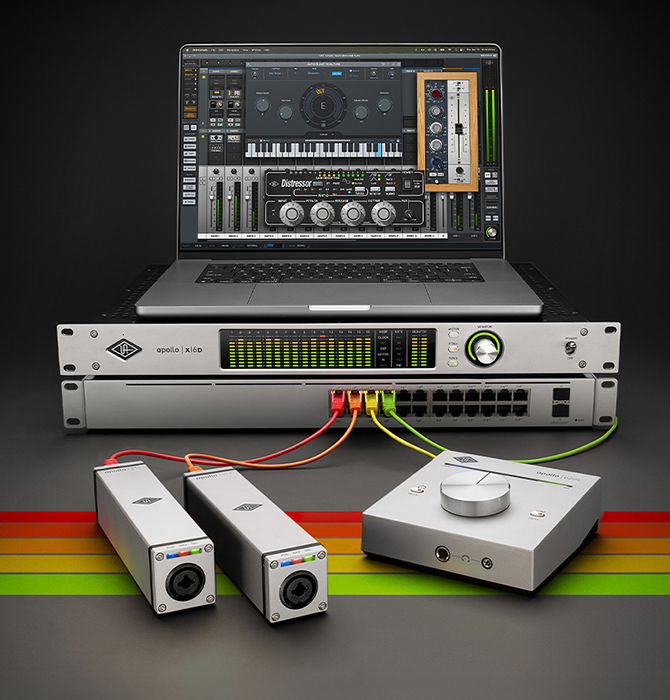An Apollo x16D and a laptop rest on top of a DANTE switch, connected to the e1x and e2m external hardware devices