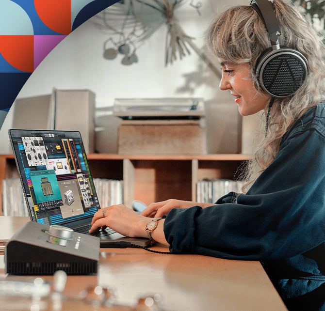Woman with headphones on sitting at laptop with UAD explore FREE plug-ins pulled up